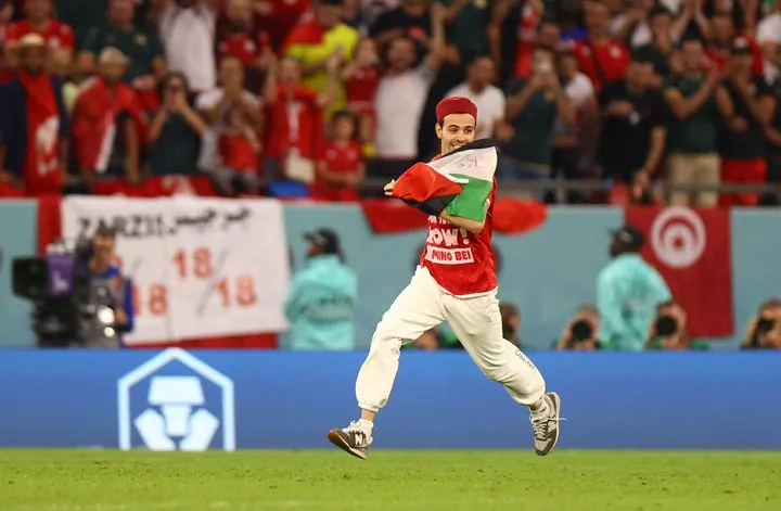 A young man weaving Palestine flag in a World Cup stadium